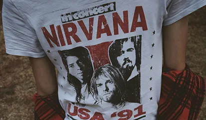 A person stands wearing a Nirvana t-shirt